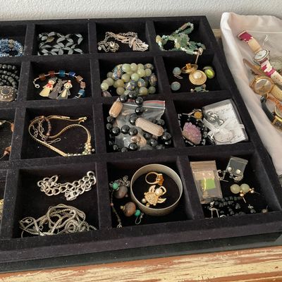 Sale Photo Thumbnail #114: Black velvet compartment tray filled with assorted costume jewelry including necklaces, bracelets, rings, and earrings, alongside several wristwatches.