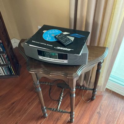 Sale Photo Thumbnail #75: Bose Wave Music System with remote, manual, and demo CD, resting on a vintage wooden accent table.