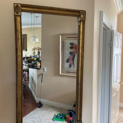 Sale Photo Thumbnail #94: Large rectangular wall mirror in a gilded frame with beaded trim and decorative corner medallions.
