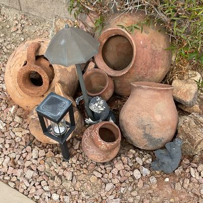 Sale Photo Thumbnail #30: Collection of rustic terracotta garden pots, landscape solar lights, and small frog figurines set among gravel and garden plants.