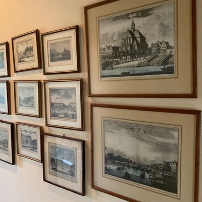 Sale Photo Thumbnail #61: Gallery wall of framed vintage architectural and landscape engravings, presented in matching wooden frames with neutral matting.