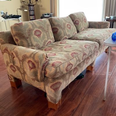 Sale Photo Thumbnail #177: Plush three-cushion sofa featuring an oversized floral tapestry pattern in muted green, beige, and pink tones with block wooden legs.