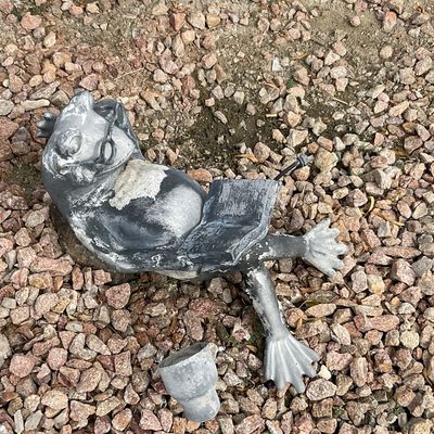 Sale Photo Thumbnail #31: Whimsical cast metal or concrete garden frog statue depicting a frog wearing glasses and reading a book, showing surface wear, paint loss, and damage.