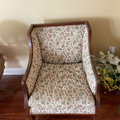 Sale Photo Thumbnail #83: Vintage wood-framed accent armchair featuring floral upholstery and curved armrests.