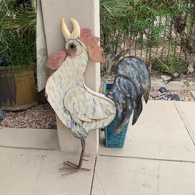 Sale Photo Thumbnail #40: Rustic painted sheet metal rooster garden statue leaning against a patio pillar.