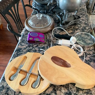 Sale Photo Thumbnail #104: Pear-shaped wooden cheese board set with recessed utensils displayed alongside a vintage pewter urn, glass serveware, and various small household items.
