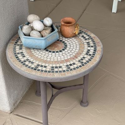 Sale Photo Thumbnail #42: Round mosaic-tile patio side table with metal base, holding a light blue hexagonal ceramic bowl with decorative eggs and a small clay pot.