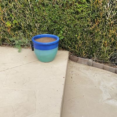 Sale Photo Thumbnail #24: Two-tone blue and teal glazed ceramic planter sitting outdoors on a stone patio.