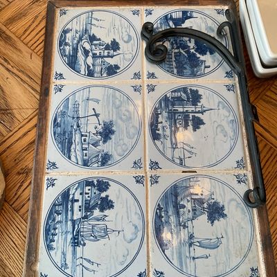 Sale Photo Thumbnail #124: Framed wooden serving tray featuring six blue and white ceramic Dutch-style Delft tiles with nautical and village scenes, alongside a black wrought iron bracket.