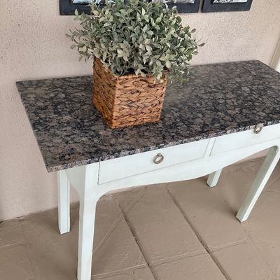 Sale Photo Thumbnail #46: White-painted console table with a mottled granite top and ring pulls, topped with a potted faux plant.