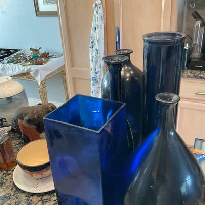 Sale Photo Thumbnail #108: Collection of cobalt blue glass vases in various shapes and sizes, displayed alongside other home decor items.