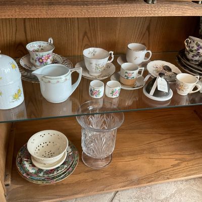 Sale Photo Thumbnail #127: Collection of vintage floral teacups, saucers, pitchers, and cut crystal vase displayed inside an oak china cabinet.