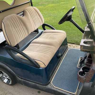 Sale Photo Thumbnail #9: Dark blue golf cart featuring upholstered tan fabric seats, custom chrome wheels, a folding windshield, and a rear utility step.