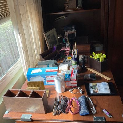 Sale Photo Thumbnail #67: Collection of office supplies, desk organizers, and reading glasses arranged on a wooden desk next to a window.