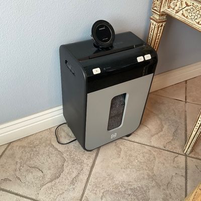 Sale Photo Thumbnail #120: TRU RED cross-cut paper shredder in black and silver with a Samsung fast wireless charger resting on top.