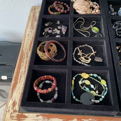 Sale Photo Thumbnail #115: Black velvet jewelry tray filled with an assortment of vintage costume jewelry, including beaded necklaces, bracelets, and earrings.