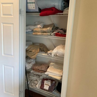 Sale Photo Thumbnail #59: Linen closet filled with various bed sheets, blankets, towels, and household linens on wire shelving.