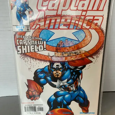 Sale Photo Thumbnail #69: Marvel Comics Captain America #9 comic book from September 1998, featuring the cover tagline "Introducing... Cap's New Shield!". The comic appears to be bagged and boarded in very good condition.