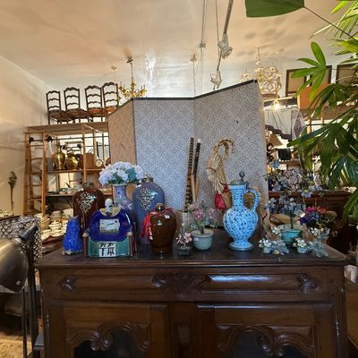 Collection of Asian decor and ceramics displayed on a carved dark wood cabinet, featuring a folding screen, blue and white pitcher, and...