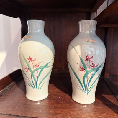 Pair of vintage pale green porcelain vases with hand-painted pink floral motifs.