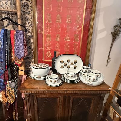Vintage Arabia Finland 'Valencia' or floral patterned ceramic dishware set displayed on a wooden cabinet, set against a large...