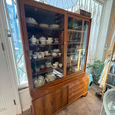 Danish Modern teak display cabinet with sliding glass upper doors, lower cabinet, and built-in drawers, filled with china and glassware.