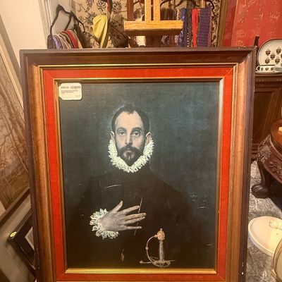 Framed reproduction print of El Greco's 'The Nobleman with his Hand on his Chest', set in a dark wood frame with a bold...