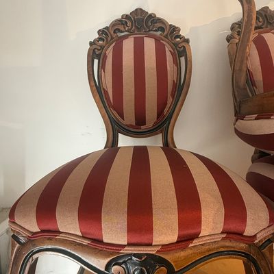 Vintage Rococo Revival-style side chair featuring a carved wooden frame with dark accents and red-and-gold striped upholstery.