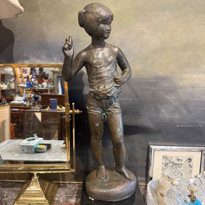 Vintage bronze figure of a young girl standing on a black stone base, showing slight green patina to the metal finish.