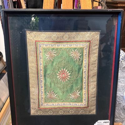 Framed Asian silk embroidery panel featuring floral motifs on a green background with metallic thread borders, presented in a black frame...