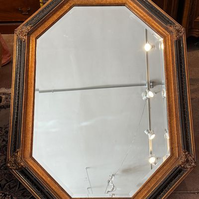Large octagonal wall mirror featuring a beveled glass edge and a distressed gold and black crackle-finish frame with ornate corner accents.