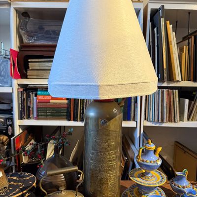 Vintage table lamp crafted from an antique General Quick Aid brass fire extinguisher, topped with a cream fabric lampshade.