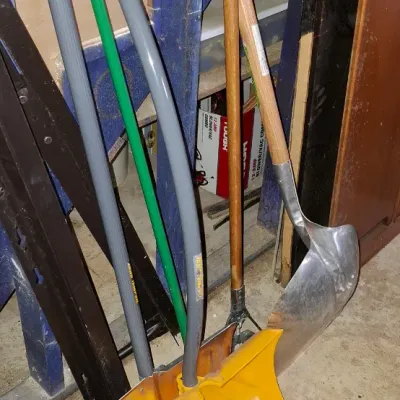 Sale Photo Thumbnail #237: Collection of assorted snow and yard shovels, including yellow plastic and aluminum blades with D-grip handles.