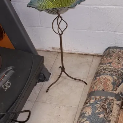 Sale Photo Thumbnail #212: Decorative birdbath or plant stand featuring a scalloped blue and green glass bowl supported by a metal pedestal base with a twisted stem.