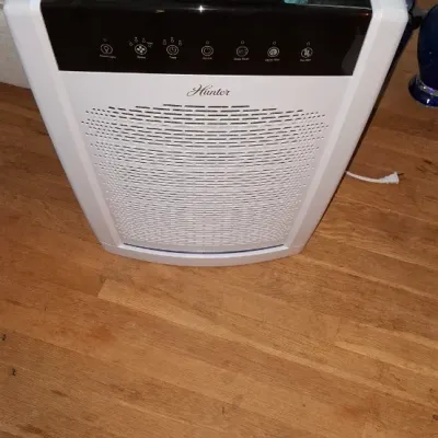 Sale Photo Thumbnail #259: White and black Hunter brand digital air purifier sitting on a hardwood floor, appearing in clean, gently used condition.