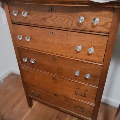 Sale Photo Thumbnail #113: Antique oak tallboy dresser with cut glass knobs, keyhole accents, and brass bail handles on the bottom drawer.