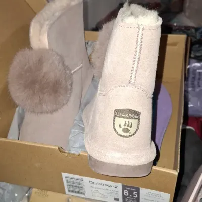 Sale Photo Thumbnail #281: Pair of Bearpaw Ridgewood Mid Wide suede boots in pink/tan with pom-pom accents, size 8.5, shown in original packaging.