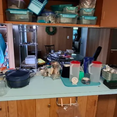 Selection of kitchen small appliances, cookware, and storage containers, including a two-slice toaster, enamel cast iron Dutch oven, and...