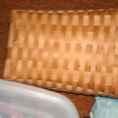 Rectangular woven wood splint basket with a sturdy wooden rim.