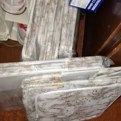 Set of packaged marble-patterned fabric storage bins, alongside a hanging closet shoe organizer and a Birkenstock shoe box.