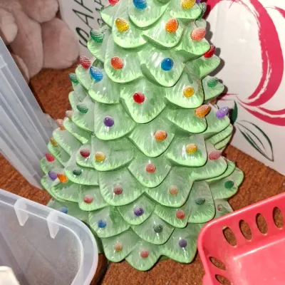 Sale Photo Thumbnail #130: Vintage green ceramic Christmas tree topped with a yellow star topper and colorful plastic peg lights.