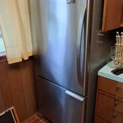 Modern Kenmore stainless steel bottom-freezer refrigerator in clean condition, displayed in a kitchen setting.