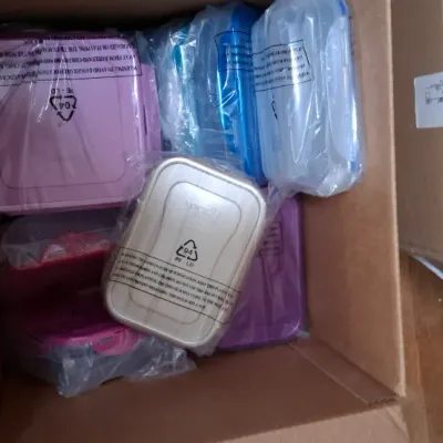 Cardboard box packed with assortment of colorful, plastic food storage containers individually wrapped in original packaging.