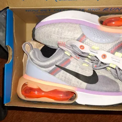 Pair of Nike Air Max running shoes in grey, purple, and orange accents, presented in their original shoe box.