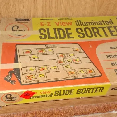 Vintage Logan E-Z View illuminated slide sorter, No. 1055, in its original box alongside a ream of printer paper.