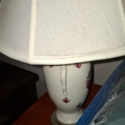 Sale Photo Thumbnail #133: Vintage white porcelain urn-style table lamp with red floral accents and a beige pleated fabric shade.