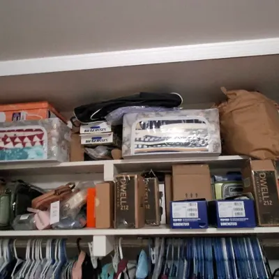Sale Photo Thumbnail #109: Closet shelves filled with various items including fabric storage bins, shoe boxes, bags, and woven baskets.