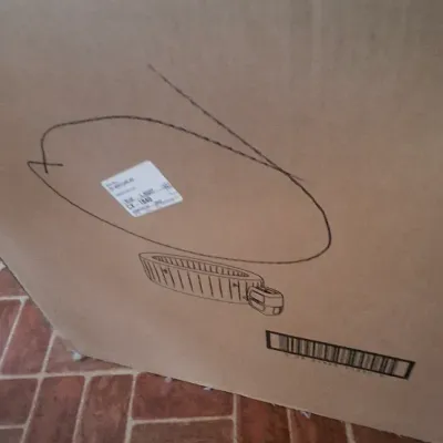 Large cardboard box for a modern portable hot tub or inflatable spa, sitting on a tiled floor.