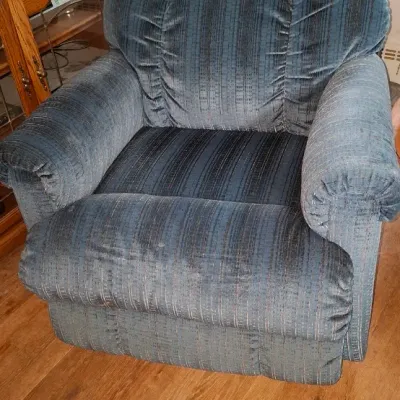 Sale Photo Thumbnail #253: Overstuffed recliner upholstered in a blue and grey striped velour fabric, showing minor surface wear.