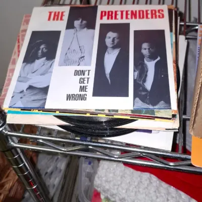 Sale Photo Thumbnail #179: Vintage 1986 The Pretenders 'Don't Get Me Wrong' 7-inch vinyl 45 RPM single sitting atop a stack of records.